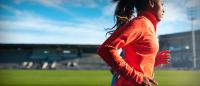 Female athlete running in sports stadium
